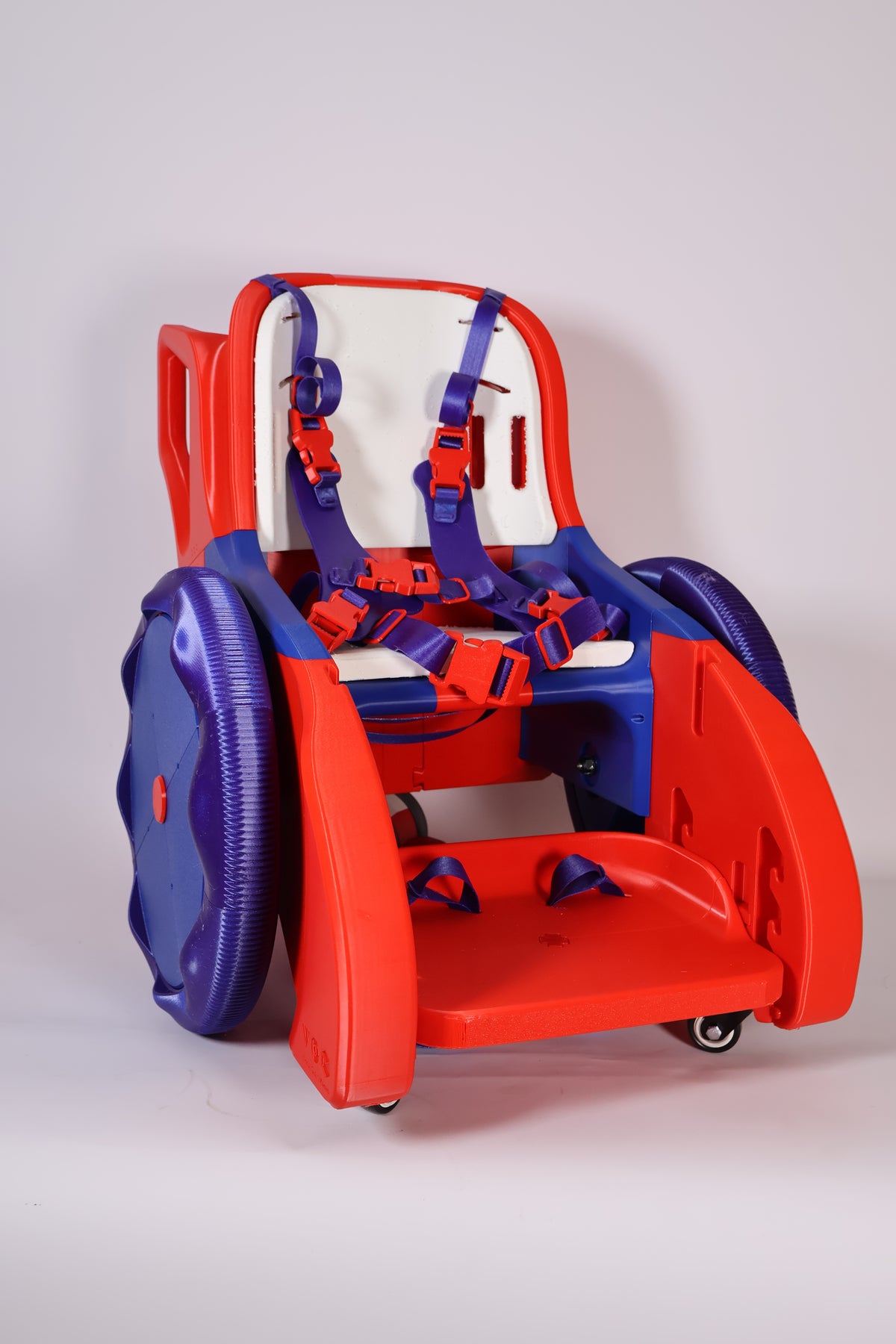 MakeGood Toddler Mobility Trainer with red frame, purple wheels, padded seat, and harness